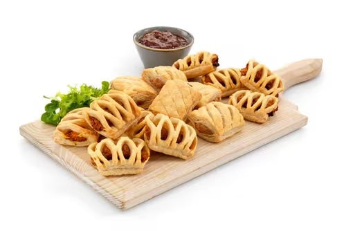 Vegan pastry rolls platter featuring Moroccan bean, sweet potato curry, and sausage rolls with sauce.