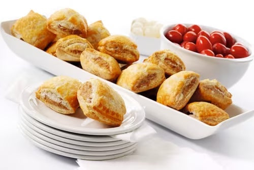 Delicious sausage rolls on a platter with cherry tomatoes, perfect for events and gatherings, served as a platter of 15 pieces.