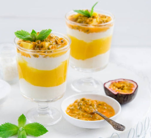 Delicious Passion Fruit Yoghurt in clear cups, layered with Greek yoghurt and topped with fresh passion fruit.
