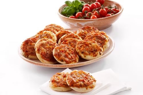 Mini Margherita pizza platter showcasing 15 delicious pieces, perfect for buffets, surrounded by fresh tomatoes.